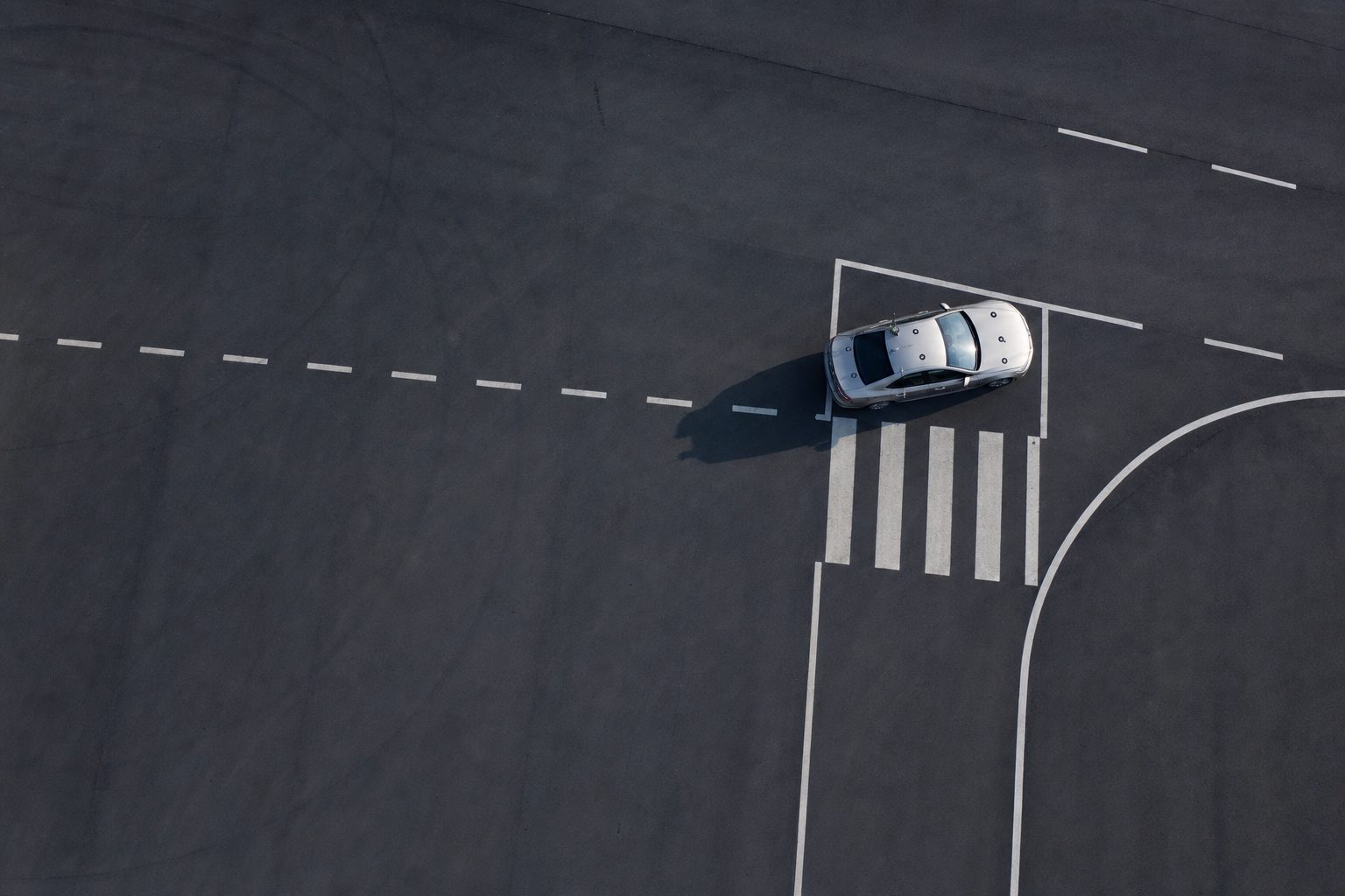 Aerial view of a vehicle proving ground with calibrated lane markings and a single test car